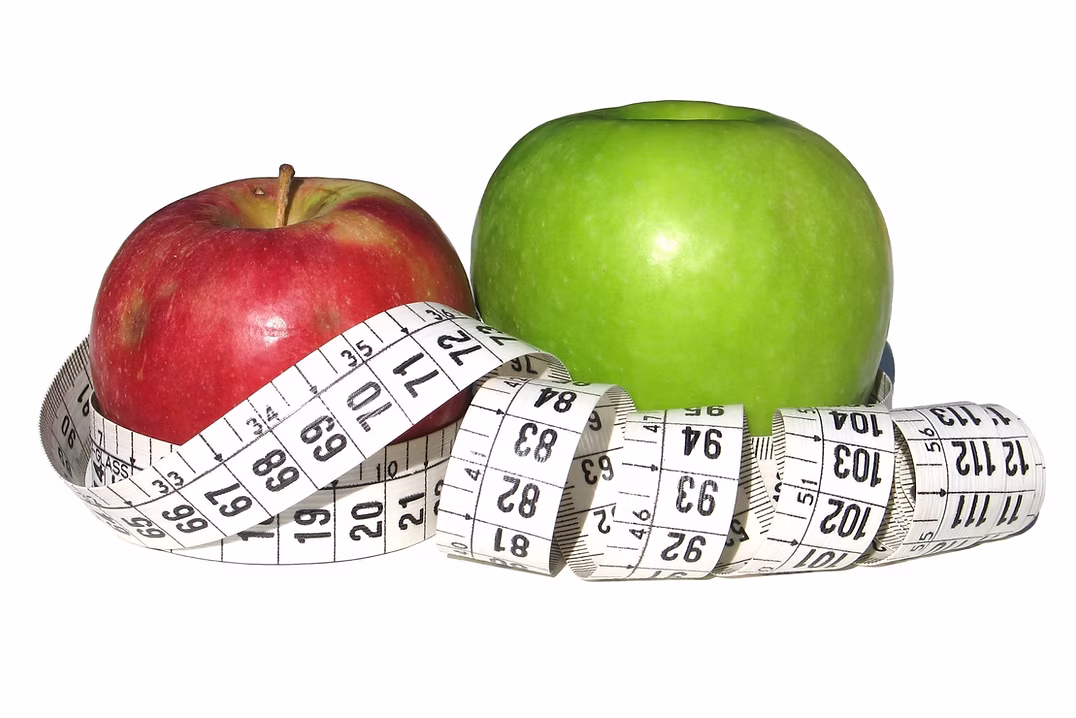 Red and green apples wrapped in a tape measure